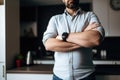 shot of an unrecognizable person standing with his arms crossed at home