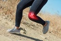 Feeling the pressure on her knee. Shot of an unrecognizable woman running outdoors with a highlighted knee injury.