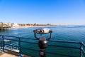 A shot of the vast blue ocean water and beach from the pier with a telescope and blue railing on the pier with blue sky Royalty Free Stock Photo