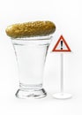 A shot of vodka with cucumber and a warning exclamation sign