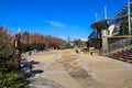 A shot of a white building with a colorful staircase, a waterfall, and a smooth stone footpath with blue sky at Little Sugar Creek