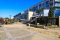 A shot of a white building with a colorful staircase, a waterfall, and a smooth stone footpath with blue sky at Little Sugar Creek