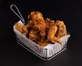 Shot of a white plate full of fried chicken on a black background