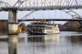 A shot of a white and red steam boat sailing on the Cumberland River near the John Seigenthaler Pedestrian Bridge Royalty Free Stock Photo