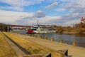 A shot of a white and red steam boat sailing on the Cumberland River near the John Seigenthaler Pedestrian Bridge Royalty Free Stock Photo