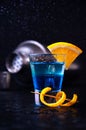 Shot with White Rum, Liquor Blue Curacao and Orange Slice. Alcoholic Layer Cocktail with Shaker on Dark Background Royalty Free Stock Photo