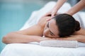 Losing herself in sublime comfort. Shot of a woman enjoying a massage beside a pool.