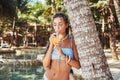 Tanned woman in bikini drinking cocktail around swimming pool Royalty Free Stock Photo