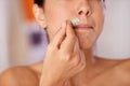 Kissable lips in the making. Shot of a woman waxing her upper lip.