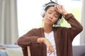 Do you have any idea how exhausting cleaning can be. Shot of a woman wearing headphones and looking exhausted after