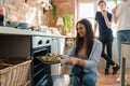 Young woman baking home pizza in kitchen at her home Royalty Free Stock Photo