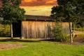 A shot of a wooden covered bridge over a river surrounded by lush green and autumn colored trees with lush green grass Royalty Free Stock Photo