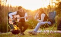 Life is better around the campfire. Shot of a you man playing his guitar to his wife outside while camping. Royalty Free Stock Photo