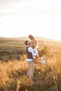 Shot of young boho hippie woman being carried by her handsome boyfriend in summer field. Couple having fun on their Royalty Free Stock Photo
