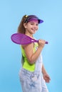 Ayoung brunette smiling girl wearing  denim overalls shorts stands with a tennis racket in his hands Royalty Free Stock Photo