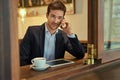 Let me get back to you.... Shot of a young businessman making a phonecall while sitting in a coffee shop. Royalty Free Stock Photo