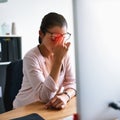Its impossible to work with this pain. Shot of a young businesswoman suffering with a headache while working in an Royalty Free Stock Photo