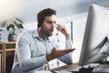 How did that happen. Shot of a young call centre agent looking upset while working late in an office. Royalty Free Stock Photo