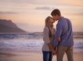 Every kiss feels like our first. Shot of a young couple enjoying a romantic kiss on the beach at sunset. Royalty Free Stock Photo