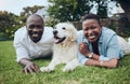 We enjoy our daily routine. Shot of a young couple lying on the grass with their dog in their garden at home. Royalty Free Stock Photo