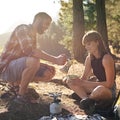 Morning coffee on the brew. Shot of a young couple making coffee on a camp stove while camping.