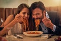 Love is all consuming. Shot of a young couple sharing a plate of spaghetti during a romantic dinner at a restaurant. Royalty Free Stock Photo