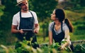 Teamwork makes growth work. Shot of a young couple using a digital tablet together while working in a garden. Royalty Free Stock Photo