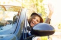 Shot of a young woman enjoying a drive in a convertible loving the breeze in her face