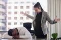 Why are you sleeping. Shot of a young female boss looking angry while a coworker sleeps in an office at work. Royalty Free Stock Photo