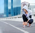 Almost time for these feet to move. Shot of a young female jogger tying up her shoes before a run through the city. Royalty Free Stock Photo