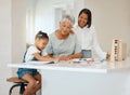 Ma, thats not a tree, its a dog. Shot of a young girl getting help from her mother and grandma while doing her homework Royalty Free Stock Photo