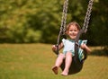 Nothing better than a swing. Shot of a young girl playing on a swing outsdie. Royalty Free Stock Photo