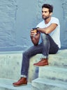 Enjoying the city the modern way. Shot of a young handsome man spending the day in the city. Royalty Free Stock Photo