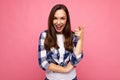 Shot of young happy smiling beautiful brunette woman with sincere emotions wearing trendy check shirt isolated on pink Royalty Free Stock Photo