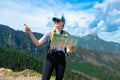 Woman traveler explorer with backpack hiking to the top of the mountain.Shot of a young lost woman holding a map while