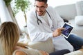 Young male gynecologist doctor showing to pregnant woman ultrasound scan baby with digital tablet. Royalty Free Stock Photo