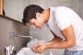 Waking himself up with some cool water. Shot of a young man catching water in his hands. Royalty Free Stock Photo