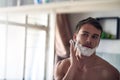 I want to look my best today. Shot of a young man shaving his beard while looking at himself in the mirror. Royalty Free Stock Photo
