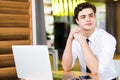 Shot of young man sitting at table looking away and thinking. Thoughtful businessman sitting home office. Sales man