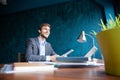 Shot of young man sitting at table looking away and thinking. Thoughtful businessman sitting in office. Royalty Free Stock Photo