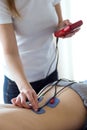 Young physioterapist applying electro stimulation in physical therapy to a patient in physio room. Royalty Free Stock Photo