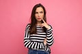 Shot of young sad dissatisfied thoughtful nice cute brunette woman with sincere emotions wearing casual striped sweater