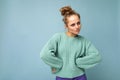 Shot of young sad upset dissatisfied angry pretty blonde woman wearing blue jersey isolated on blue background with