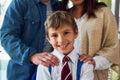 Ready for school. Shot of a young schoolboy standing with his parents.