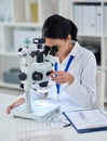 Theres nothing her microscope cant find. Shot of a young scientist using a microscope in a laboratory. Royalty Free Stock Photo