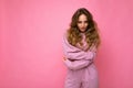 Shot of young self-concentrated pretty blonde woman wearing pink hoodie isolated on pink background with empty space Royalty Free Stock Photo