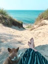 A young stylish hipster woman with dog puppy chihuahua on the beach, cool outfit, romantic mood, having fun, sunny, horizontal,