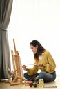 Shot of a young woman artist painting at home creative while sitting on floor. Royalty Free Stock Photo