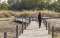 Shot of a young woman crossing wooden bridge. Outdoors