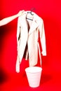 Shot of a young woman hand throwing her outwear dress in the trash isolated on red background Royalty Free Stock Photo